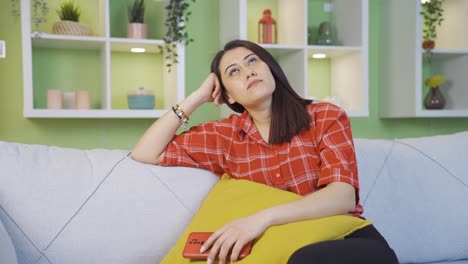 Unhappy-young-woman-looking-at-phone-helplessly-at-home.